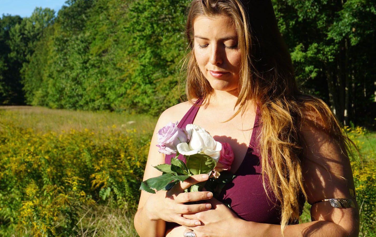 Amanda Ananda holding roses in field